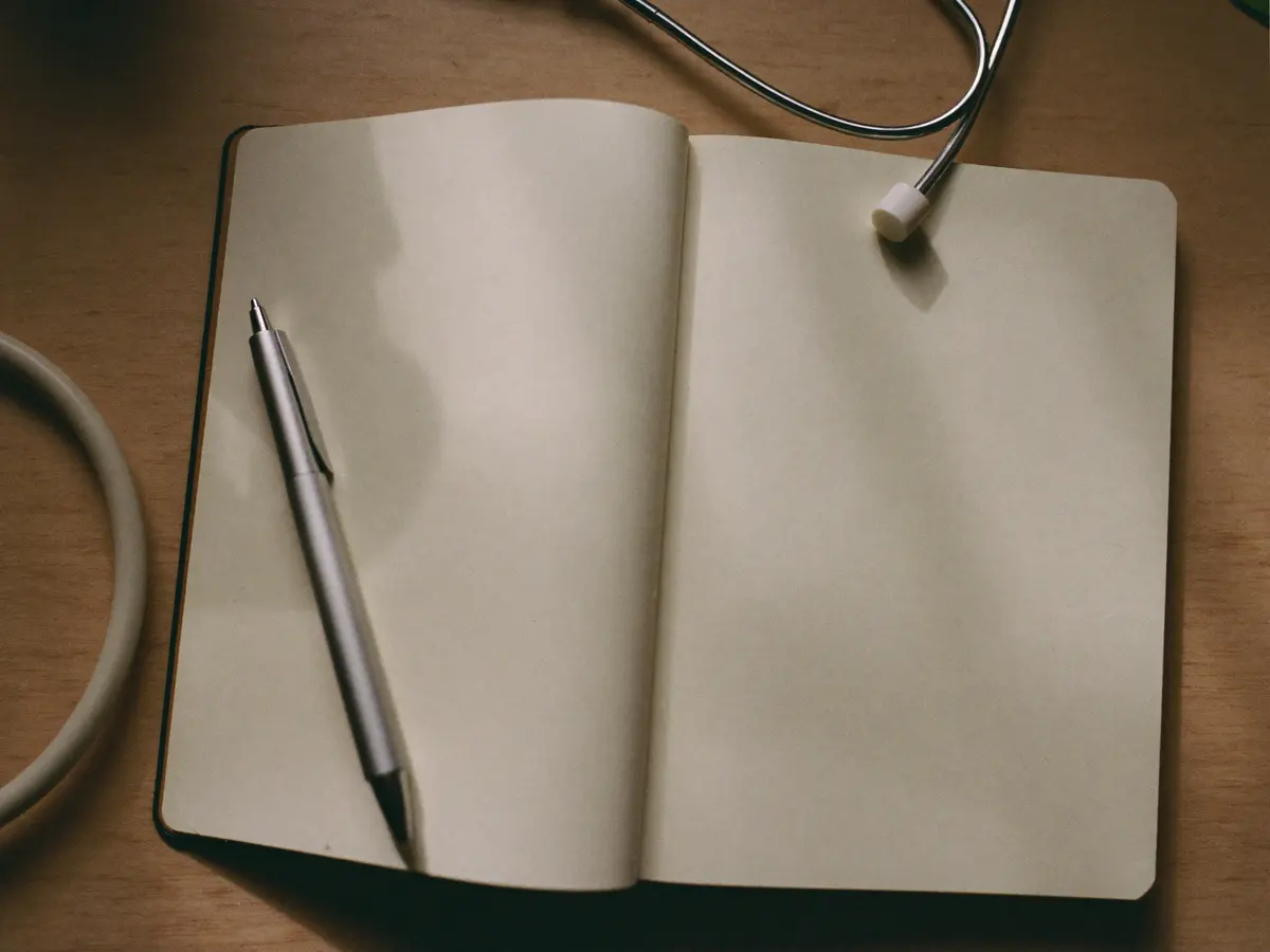 Blank notebook with a pen and stethoscope